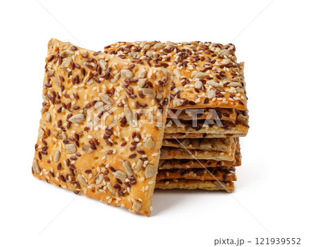 Crunchy seed crackers stacked neatly on a white background ready for a healthy snack option or recipe enhancement 121939552