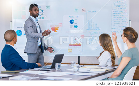 Presentation, strategy discussion or meeting of business man briefing his colleagues in a boardroom. African American leader accountant answers questions in an office while discussing finance 121939621