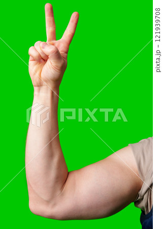 A strong arm making a peace sign against a vibrant green background 121939708
