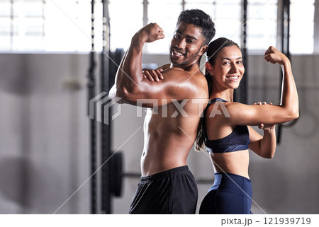 Fitness, flexing muscles and strong couple goals while doing exercise or training in a gym. Portrait of fit sports people, woman or man showing off their biceps after exercising for arm strength 121939719