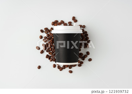 A paper coffee cup surrounded by freshly roasted coffee beans on a clean white background A paper coffee cup surrounded by freshly roasted coffee beans on a clean white background 121939732