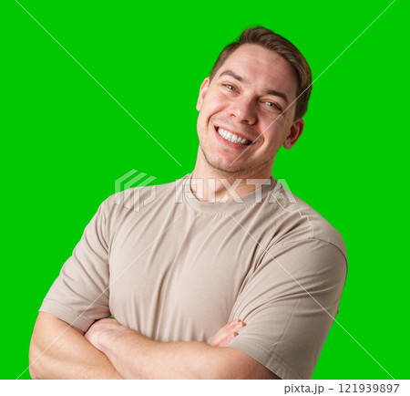 Smiling man in a beige shirt poses against a bright green background Smiling man in a beige shirt poses against a bright green background 121939897