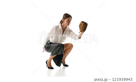Woman crouched holding baseball glove, embodying strategic preparation and concentration in decision-making against white studio background. 121939943
