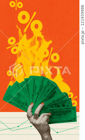 Green dollar bills in hand with fire and percentage signs, symbolizing inflation and rising interest rates. Conceptual creative design. 121939986