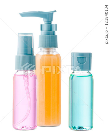 Various bottles with colored liquids and pumps arranged on white background 121940134