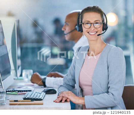 Woman call center agent working in office, employee looking confident and helping people online on computer at work. Portrait of happy customer service worker giving support at startup company Woman call center agent working in office, employee looking confident and helping people online on computer at work. Portrait of happy customer service worker giving support at startup company 121940135
