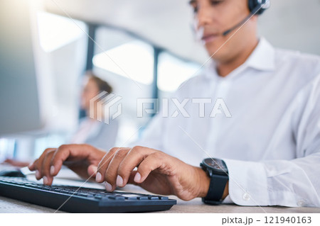 Call center agent hands or CRM consultant typing client information on PC keyboard while talking on phone with headset. Contact us for customer service or telemarketing hotline support assistance. 121940163