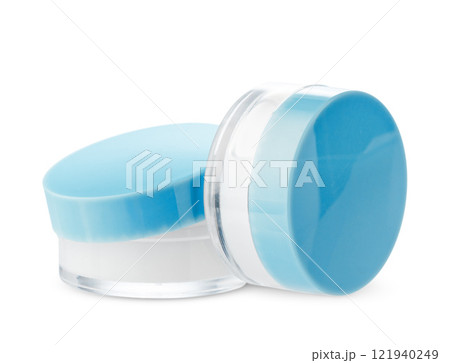Open cosmetic jars showcasing different creams set against a clean white background 121940249