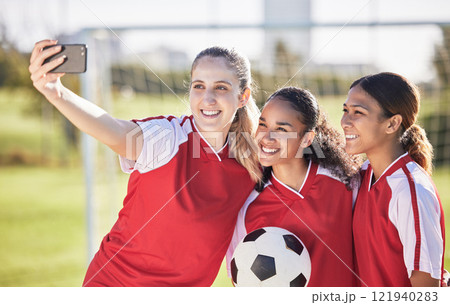 Selfie, soccer and sports team smiling and feeling happy while posing for a social media picture. Diverse and young girls standing together on a football field. Friends and teammates enjoying a match Selfie, soccer and sports team smiling and feeling happy while posing for a social media picture. Diverse and young girls standing together on a football field. Friends and teammates enjoying a match 121940283