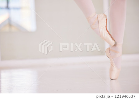 Ballet feet or legs on the tiptoe dancing or practicing in a dance studio or class with copy space. Closeup of an elegant dancer or ballerina in pointe shoes preparing for a performance 121940337