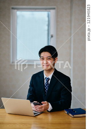 スマホを操作する20代の若い男性 スマホを操作する20代の若い男性 121940823