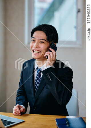 電話をする20代の若い男性 電話をする20代の若い男性 121940826