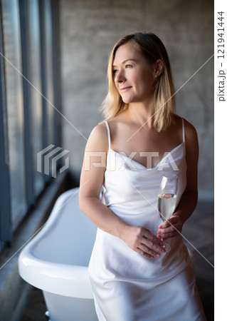 Woman relax with glass of vine in bathrobe at home, closeup 121941444