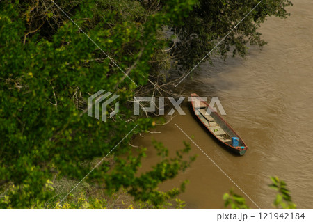 Canoe Moored on a Riverbank 121942184