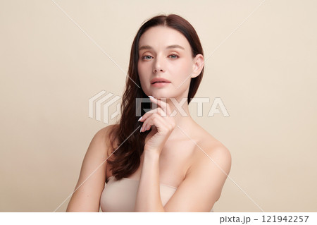 Beautiful young woman with clean fresh skin on beige background, Face care, Facial treatment, Cosmetology, beauty and spa, women portrait. Beautiful young woman with clean fresh skin on beige background, Face care, Facial treatment, Cosmetology, beauty and spa, women portrait. 121942257
