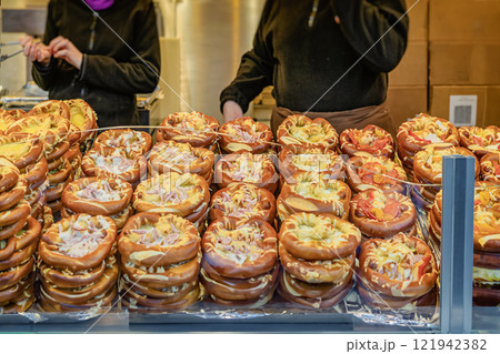 Stuffed pretzels with cheese and toppings at market stall. Concept of innovative street food Stuffed pretzels with cheese and toppings at market stall. Concept of innovative street food 121942382