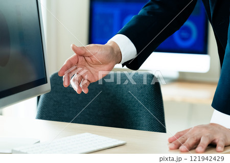 パソコンの前で説明するビジネスマン 121942429