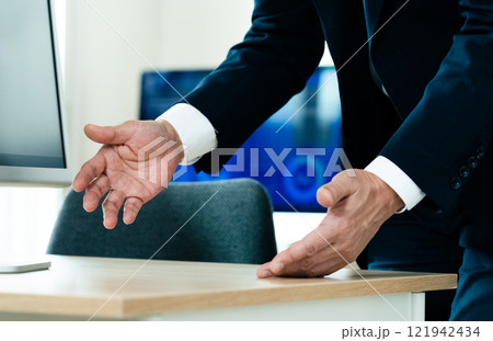 パソコンの前で説明するビジネスマン 121942434