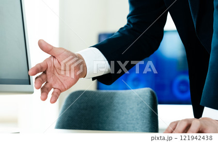 パソコンの前で説明するビジネスマン 121942438