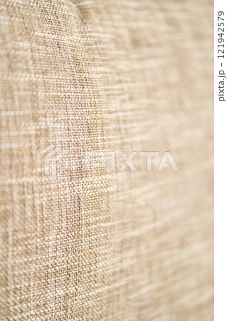 Textured beige fabric close up showing detailed weave pattern and natural 121942579