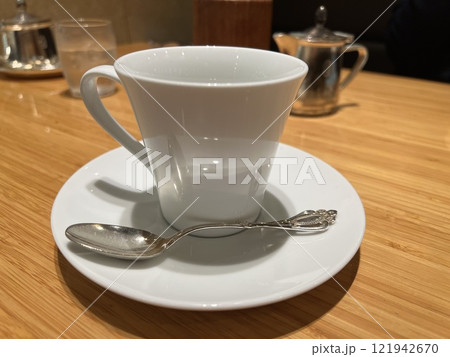 木目のテーブルに置かれた空のコーヒーカップとソーサー 木目のテーブルに置かれた空のコーヒーカップとソーサー 121942670