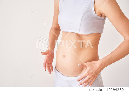 Caucasian female adult in sportswear showing post pregnancy belly and stretch 121942794