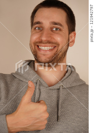 Young handsome man with beard over isolated gray background giving a thumbs up gesture. 121942797