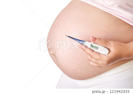Pregnant caucasian female holding thermometer showing temperature wearing white 121942835