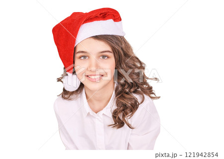 Caucasian female teen smiling in santa hat with curly brown hair and white shirt Caucasian female teen smiling in santa hat with curly brown hair and white shirt 121942854