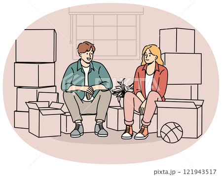 Couple sitting among boxes of belongings after moving into new house or apartment 121943517
