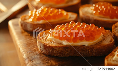 Red caviar on toasted bread with butter, close-up view. Gourmet appetizer and luxury delicacy concept 121944602