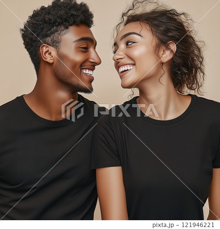 A man and a woman are joyfully looking at each other while smiling. Black cotton couple t-shirts mockup 121946221