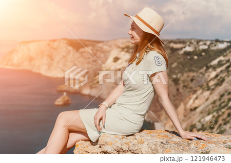 Woman travel sea. Happy tourist in hat enjoy taking picture outdoors for memories. Woman traveler posing on the beach at sea surrounded by volcanic mountains, sharing travel adventure journey Woman travel sea. Happy tourist in hat enjoy taking picture outdoors for memories. Woman traveler posing on the beach at sea surrounded by volcanic mountains, sharing travel adventure journey 121946473