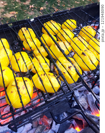 potatoes are baked on a grill over hot coals potatoes are baked on a grill over hot coals 121948090