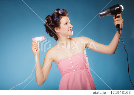 girl with curlers in hair holds hairdreyers girl with curlers in hair holds hairdreyers 121948168