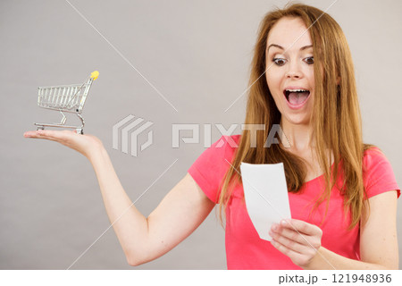 Woman with bill and shopping cart Woman with bill and shopping cart 121948936
