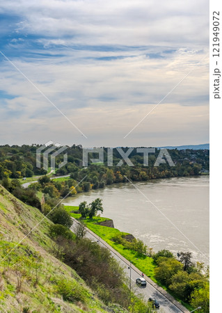 The fortress perched on Petrovaradin Hill watches over the city, while the charming streets and modern buildings of Novi Sad are spread out, creating a perfect blend of history and contemporary life 121949072