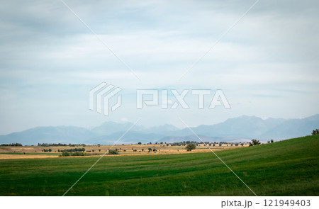 green hill against the backdrop of high mountains and storm clouds green hill against the backdrop of high mountains and storm clouds 121949403