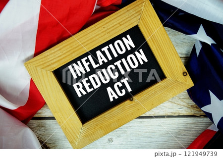 Inflation Reduction Act text messege with USA flag on wooden background Inflation Reduction Act text messege with USA flag on wooden background 121949739