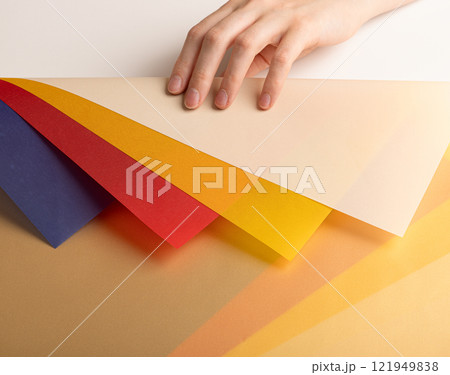Layered paper background with translucent beige, red, yellow, orange, and blue sheets. Multicolored 121949838