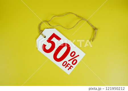 Sale 50% off text message on price tag top view on yellow background, business and promotion concep 121950212