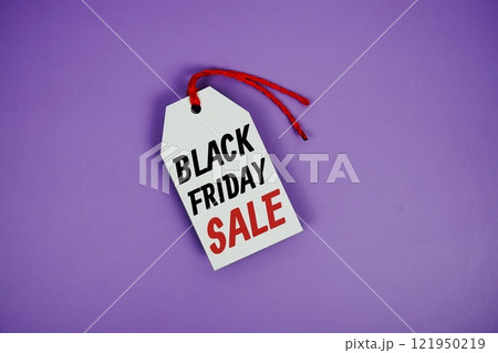 Black Friday Sale on price tag with wooden clothes hanger top view on purple background Black Friday Sale on price tag with wooden clothes hanger top view on purple background 121950219