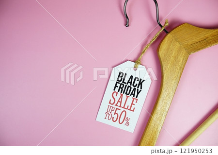 Black Friday Sale up to 50% on price tag with wooden clothes hanger top view on pink background Black Friday Sale up to 50% on price tag with wooden clothes hanger top view on pink background 121950253