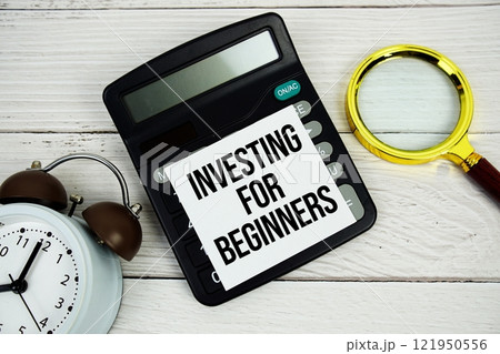 Investing For Beginners text message on sticky note with magnifying glass and alarm clock on wooden background Investing For Beginners text message on sticky note with magnifying glass and alarm clock on wooden background 121950556