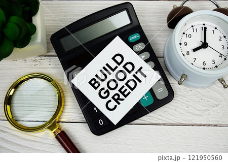 Build Good Credit text message with calculate, alarm clock and magnifying glass on wooden background Build Good Credit text message with calculate, alarm clock and magnifying glass on wooden background 121950560