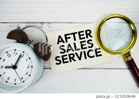 After Sales Service text message on sticky note with magnifying glass and alarm clock on wooden 121950646