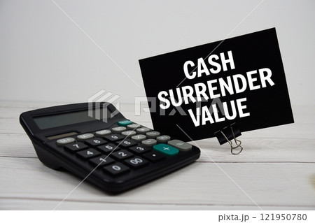 Cash Surrender Value text message on sticky note with calculator on wooden background 121950780