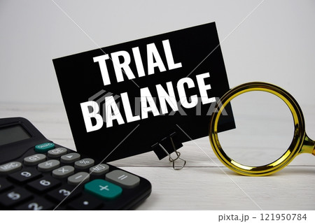 Trial Balance text message with calculate and magnifying glass on wooden background 121950784