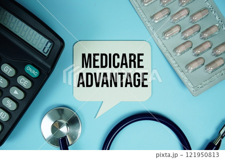 Medicare Advantage text on speech bubble with calculator and stethoscope top view on blue background Medicare Advantage text on speech bubble with calculator and stethoscope top view on blue background 121950813