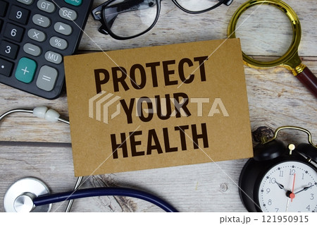 Protect Your Health text with calculator, magnifying glass and alarm clock on wooden background Protect Your Health text with calculator, magnifying glass and alarm clock on wooden background 121950915
